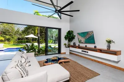 a living room with a white couch and a ceiling fan at Beachside Bliss 4BR Lux Villa, Pool, Terrace, Golf in San José Pinilla