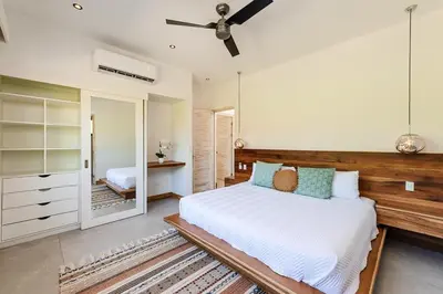 a bedroom with a large bed and a mirror at Beachside Bliss 4BR Lux Villa, Pool, Terrace, Golf in San José Pinilla
