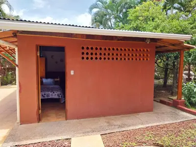 a small orange shed with a bed in it at las cabinas del sueño in Nicoya
