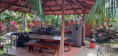 a outdoor kitchen with a table and a stove at las cabinas del sueño in Nicoya
