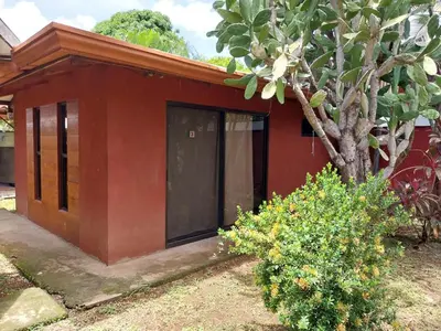 a red house with a tree in front of it at Las cabinas del sueño in Nicoya