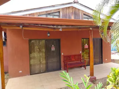 a house with a red bench in front of it at Las cabinas del sueño in Nicoya