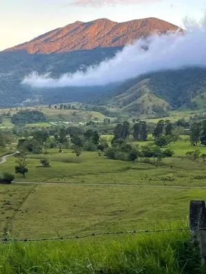 a view of a green field with mountains in the background at Cabaña2 Mirador Jacuzzi in Sarchí