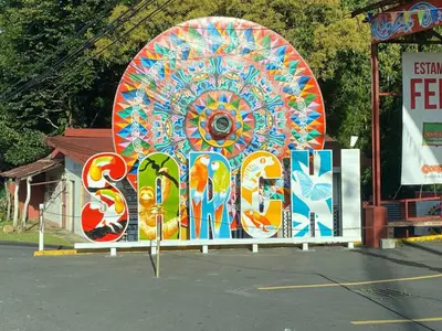a large colorful sign in a parking lot at Cabaña2 Mirador Jacuzzi in Sarchí