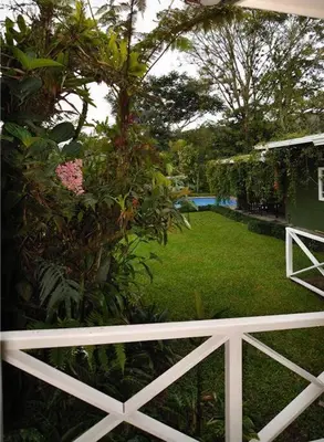 a view of a garden with a white fence at Cabin at Los Titos Coffee Farm in Recreo