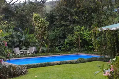a swimming pool in the yard of a house at Cabin at Los Titos Coffee Farm in Recreo