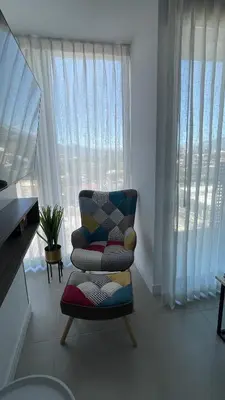 a living room with a chair and a large window at SkyGarden Nunciatura Luxury Apartment #705 in San José