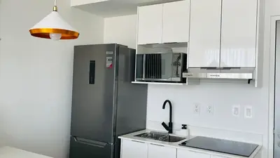 a kitchen with a stainless steel refrigerator and white cabinets at SkyGarden Nunciatura Luxury Apartment #705 in San José