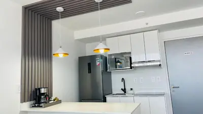a kitchen with white cabinets and a black refrigerator at SkyGarden Nunciatura Luxury Apartment #705 in San José