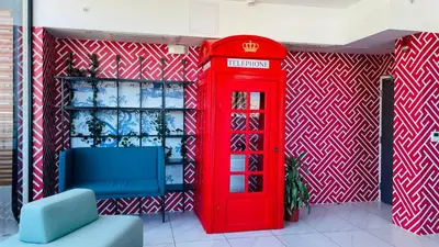a red phone booth next to a blue chair and a red telephone box at SkyGarden Nunciatura Luxury Apartment #705 in San José