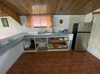 a small kitchen with a sink and a refrigerator at Jardín Del Bosque in Bijagua
