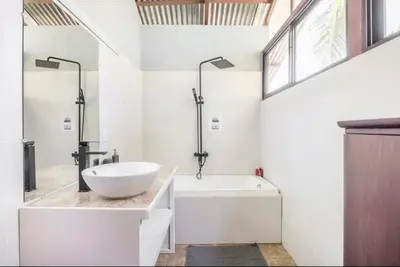 a bathroom with a white tub and a sink and a bath tub at Casa Patricia in Uvita