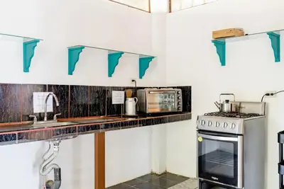 a kitchen with a counter with blue shelves at Casa Patricia in Uvita
