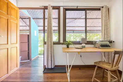 an office with a desk and two windows at Casa Patricia in Uvita
