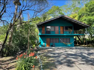 a blue house in the middle of a forest at Casa Patricia in Uvita