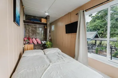 a bedroom with a bed and a large window at Ronnys Flat Manuel Antonio in Quepos
