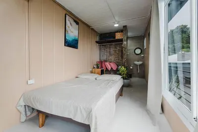 a bedroom with a bed and a large window at Ronnys Flat Manuel Antonio in Quepos