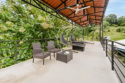 a group of chairs and tables on a balcony at Ronnys Flat Manuel Antonio in Quepos
