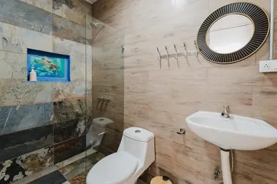 a bathroom with a sink and a toilet and a mirror at Ronnys Flat Manuel Antonio in Quepos