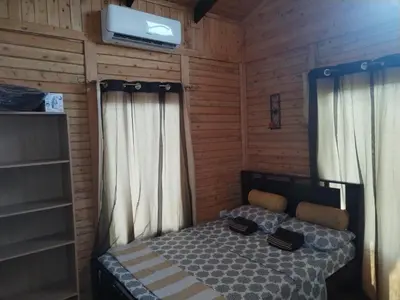 a bedroom with a bed and a tv on the wall at Cabaña la Corteza in Tanque