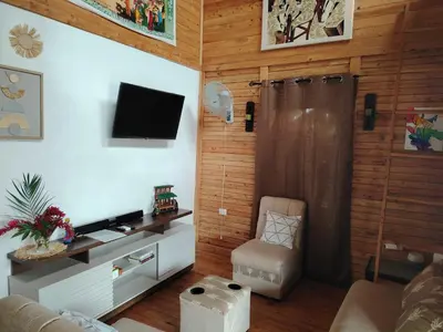 a living room with a television and a chair at Cabaña la Corteza in Tanque