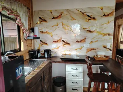 a kitchen with a marble wall with a table and chairs at Cabaña la Corteza in Tanque