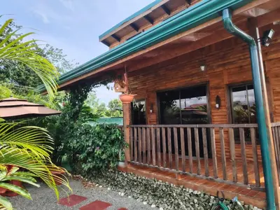 a log cabin with a porch and windows at Cabaña la Corteza in Tanque
