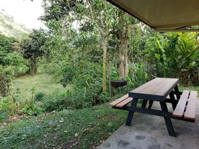 a wooden picnic table sitting under a tent at Studio House in Eco-Farm: nature, relaxing, hiking in Turrialba