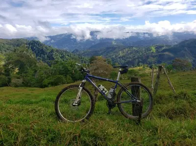 a bike parked in a field with mountains in the background at Studio House in Eco-Farm: nature, relaxing, hiking in Turrialba