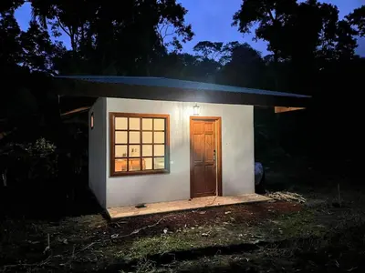 a small house with a door and a window at Cabaña junto al río in Naranjito