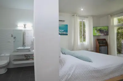 a white bedroom with a bed and a sink at Mi Casa-stroll to the beach, ideal for 3-7 guest in Santa Cruz