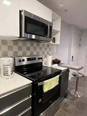 a kitchen with a stove and a microwave at Pura Vida Hub - Iconnia - Cash Only in San José