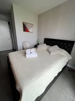 a bedroom with a large bed with two towels on it at Pura Vida Hub - Iconnia - Cash Only in San José