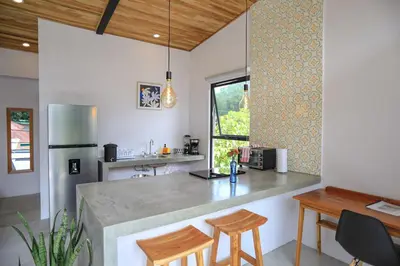a kitchen with a counter and a table and chairs at Magic Place in Santa Teresa Beach