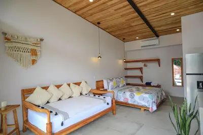a living room with two beds and a refrigerator at Magic Place in Santa Teresa Beach