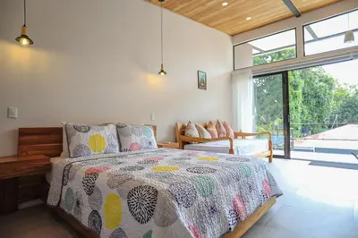 a bedroom with a bed and a large window at Magic Place in Santa Teresa Beach