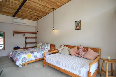 a bedroom with a bed and a bed and a table at Magic Place in Santa Teresa Beach