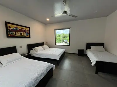 a room with two beds and a window at Amazilia Guesthouse in Liberia