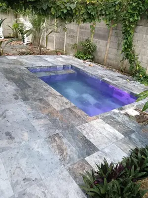 a pool with blue water in a patio at Uvita Stone House in Uvita
