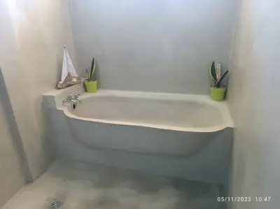 a white bath tub with two plants in a bathroom at Uvita Stone House in Uvita