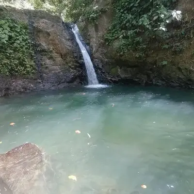 a waterfall in the middle of a pool of water at Uvita Stone House in Uvita