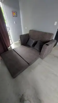 a brown couch sitting in a living room at Uvita Stone House in Uvita