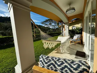 a porch with a hammock on a house at Luxury Condo at Los Sueños Resort & Marina in La Mona