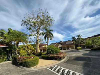 a parking lot at a house with palm trees and bushes at Luxury Condo at Los Sueños Resort & Marina in La Mona