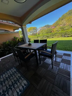 a patio with a wooden table and chairs on a deck at Luxury Condo at Los Sueños Resort & Marina in La Mona
