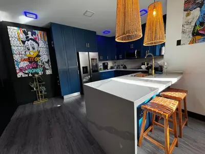 a kitchen with blue cabinets and a counter with stools at Luxury Condo at Los Sueños Resort & Marina in La Mona