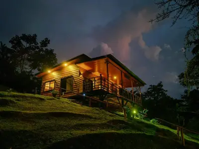 a wooden cabin on a hill at night at Ceibo Lodge, great birdwatching in Bijagual