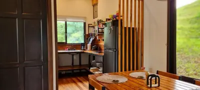 a kitchen with a wooden table and a refrigerator at Ceibo Lodge, great birdwatching in Bijagual