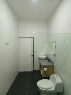 a white bathroom with a toilet and a sink at Toucan home in Fortuna