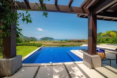 a view of the pool from the patio of a villa at Casa Blue Sail 6 bdrs ocean view in Los Suenos in Herradura